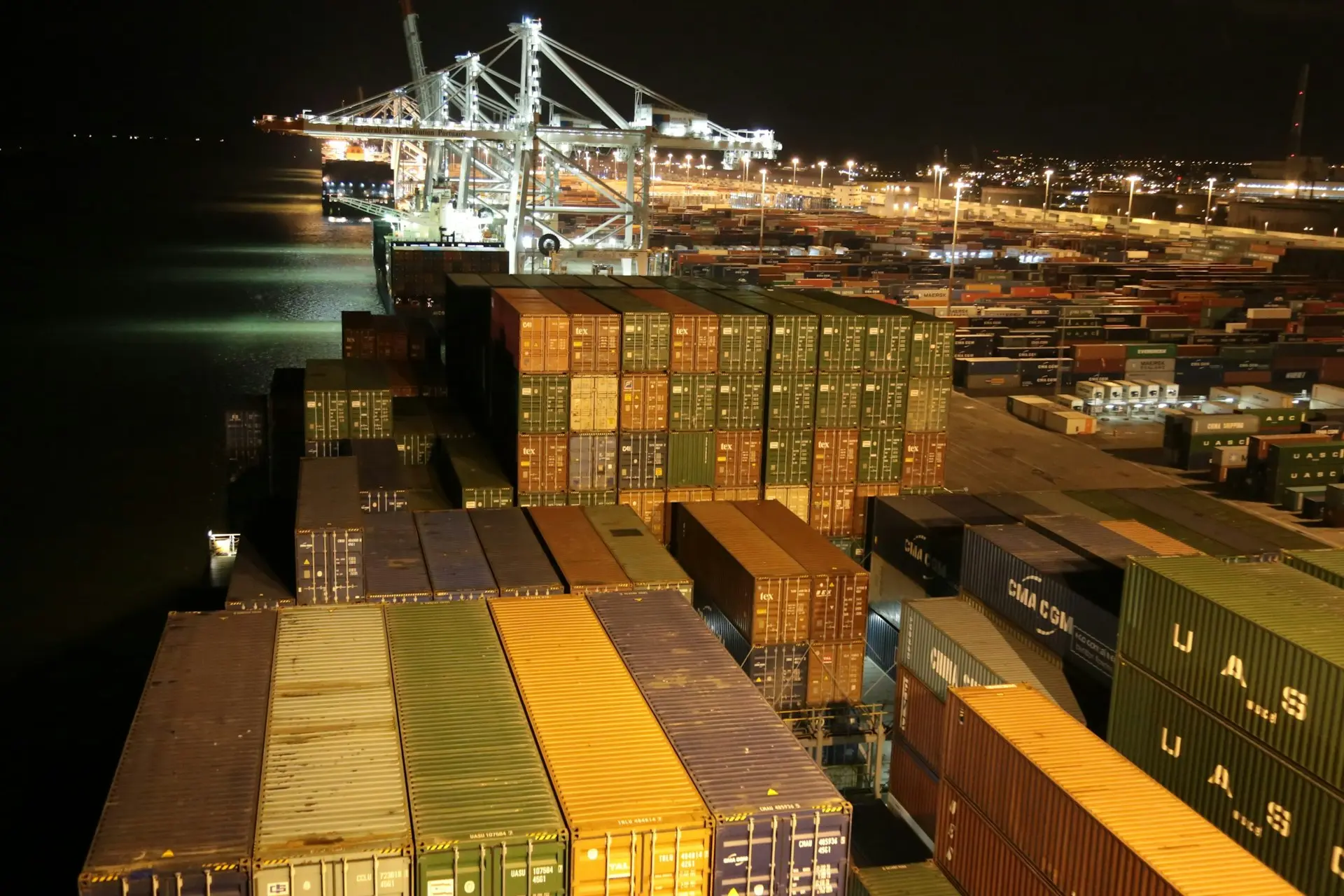 cargo containers are stacked on top of each other at night